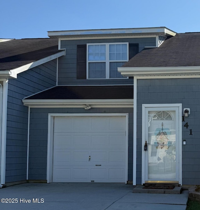 141 Jessie Cir, Hubert, NC 28539 - view of exterior entry with a shingled roof, driveway, and an attached garage