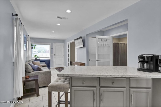 323 Cape Fear Blvd, Wilmington, NC 28401 - kitchen featuring gray cabinets, open floor plan, recessed lighting, light stone countertops, and a peninsula