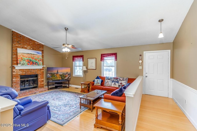 4909 Creekside Dr, New Bern, NC 28562 - living area featuring light wood-type flooring, ceiling fan, lofted ceiling, and a brick fireplace