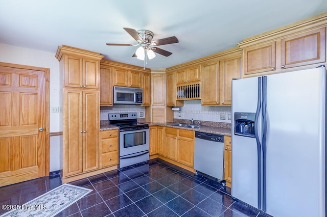 4909 Creekside Dr, New Bern, NC 28562 - kitchen featuring appliances with stainless steel finishes, a sink, backsplash, ceiling fan, and dark stone countertops