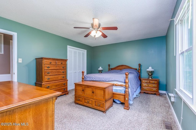 4909 Creekside Dr, New Bern, NC 28562 - bedroom featuring a closet, light carpet, a textured ceiling, and a ceiling fan