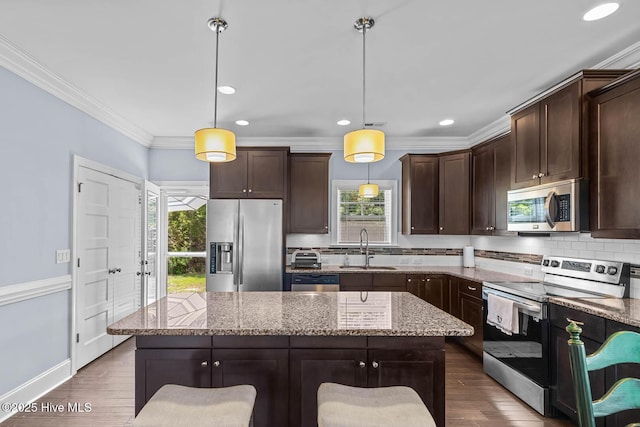 266 Marsh Haven Dr, Sneads Ferry, NC 28460 - kitchen featuring stainless steel appliances, a sink, plenty of natural light, dark brown cabinetry, and ornamental molding