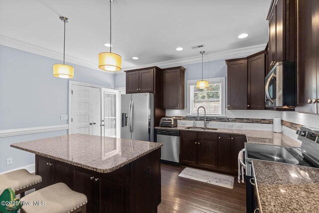 266 Marsh Haven Dr, Sneads Ferry, NC 28460 - kitchen with stainless steel appliances, a sink, crown molding, dark brown cabinetry, and decorative backsplash