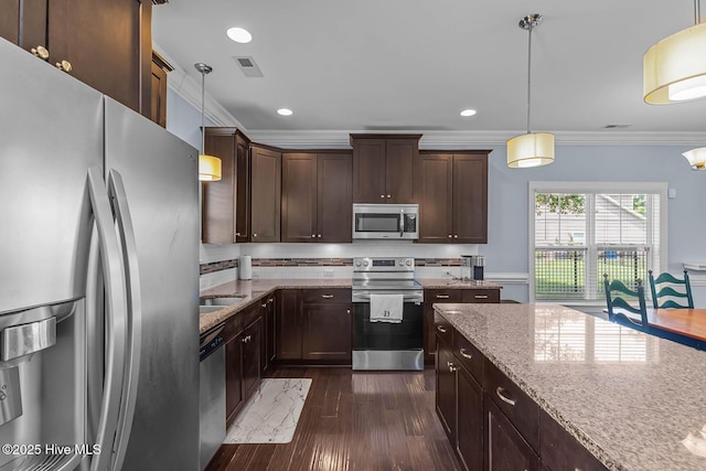 266 Marsh Haven Dr, Sneads Ferry, NC 28460 - kitchen featuring stainless steel appliances, dark brown cabinetry, light stone counters, crown molding, and pendant lighting