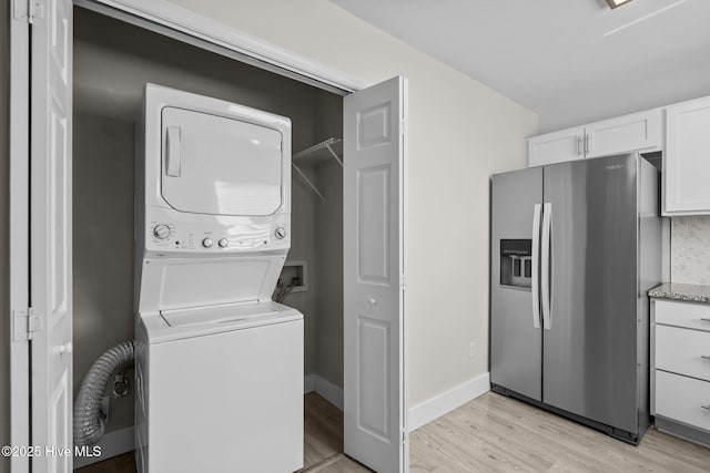 120 NW 19th St, Oak Island, NC 28465 - laundry area with stacked washer / dryer and light wood-style floors