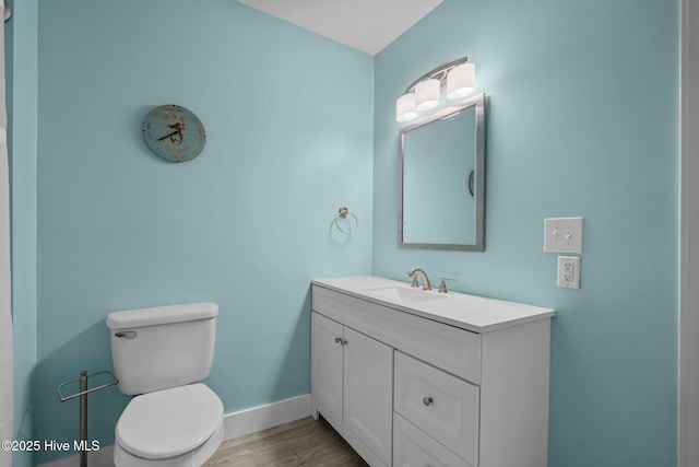 120 NW 19th St, Oak Island, NC 28465 - bathroom featuring vanity, toilet, wood finished floors, and baseboards