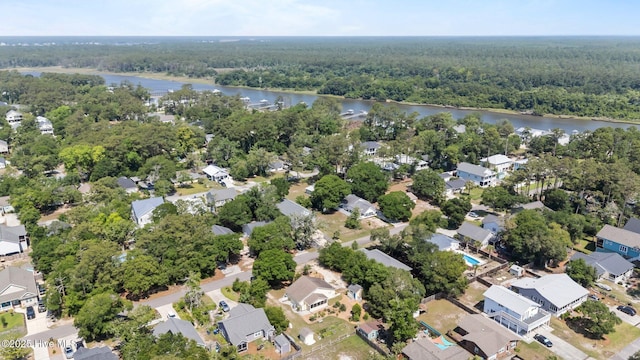 120 NW 19th St, Oak Island, NC 28465 - aerial overview of property's location with a heavily wooded area, a large body of water, and nearby suburban area
