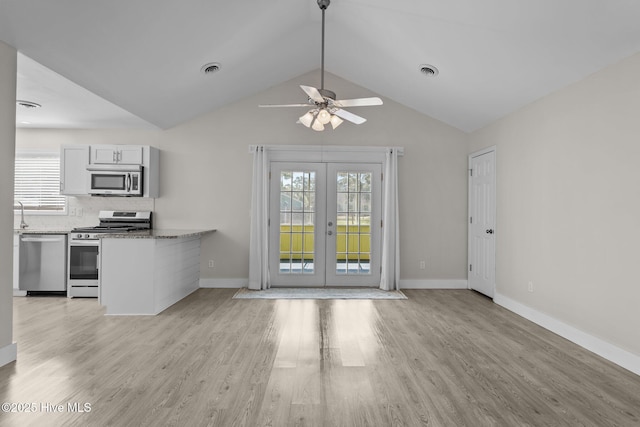 120 NW 19th St, Oak Island, NC 28465 - kitchen with appliances with stainless steel finishes, french doors, healthy amount of natural light, light wood-style floors, and vaulted ceiling