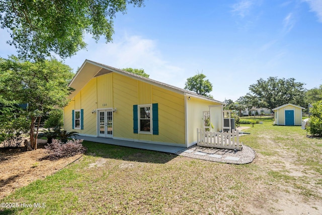 120 NW 19th St, Oak Island, NC 28465 - view of home's exterior with french doors and a lawn