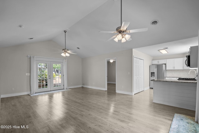 120 NW 19th St, Oak Island, NC 28465 - unfurnished living room featuring ceiling fan, lofted ceiling, light wood-style floors, baseboards, and french doors