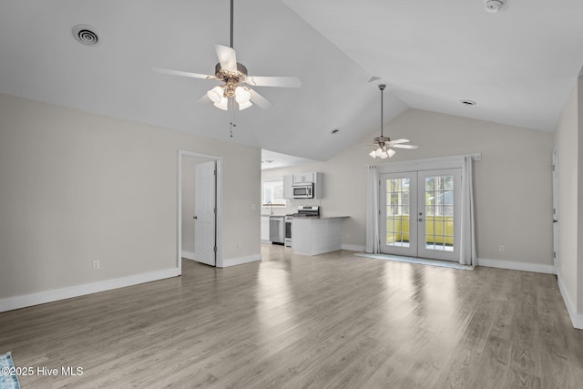 120 NW 19th St, Oak Island, NC 28465 - unfurnished living room with a ceiling fan, vaulted ceiling, plenty of natural light, french doors, and light wood-style flooring
