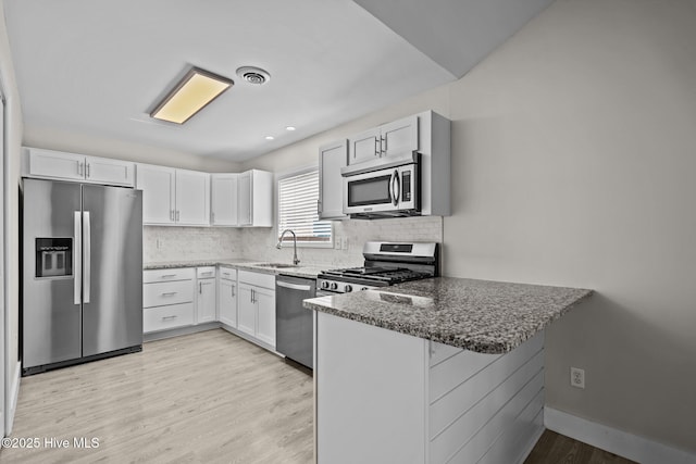 120 NW 19th St, Oak Island, NC 28465 - kitchen with appliances with stainless steel finishes, a sink, a peninsula, and stone counters