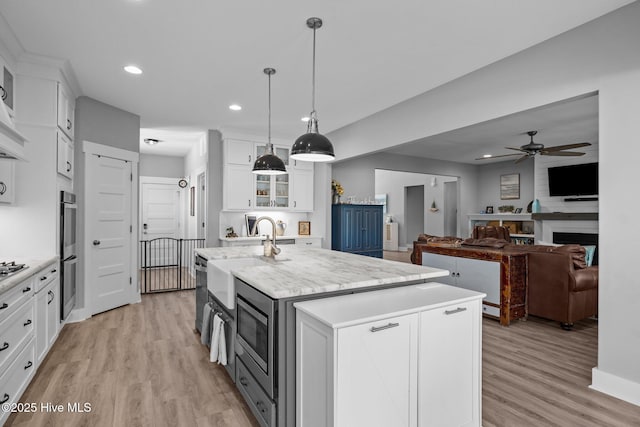 601 Trawler Pl, Newport, NC 28570 - kitchen featuring a sink, appliances with stainless steel finishes, light wood-style floors, white cabinets, and a ceiling fan
