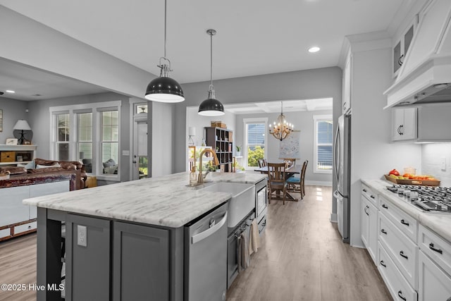 601 Trawler Pl, Newport, NC 28570 - kitchen featuring appliances with stainless steel finishes, custom exhaust hood, a sink, light wood-type flooring, and white cabinets