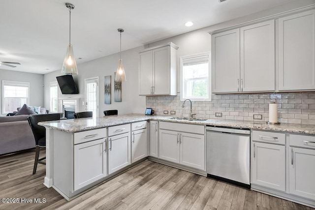 2610 Longleaf Pine Cir, Leland, NC 28451 - kitchen featuring dishwasher, a sink, a peninsula, open floor plan, and a fireplace