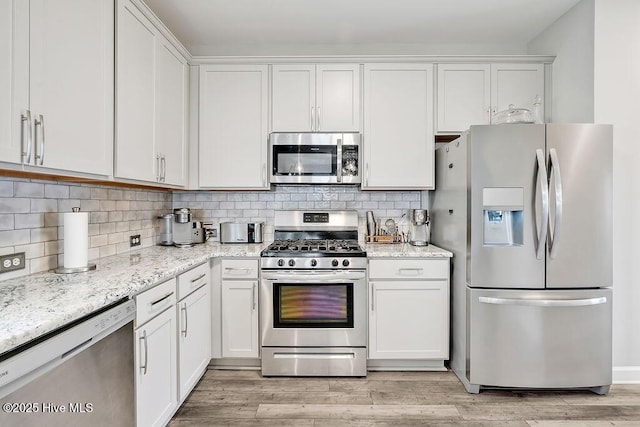 2610 Longleaf Pine Cir, Leland, NC 28451 - kitchen with stainless steel appliances, white cabinetry, and tasteful backsplash