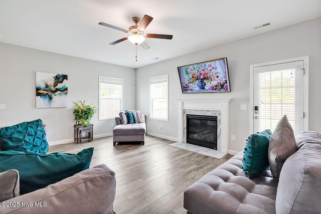 2610 Longleaf Pine Cir, Leland, NC 28451 - living area featuring a ceiling fan, wood finished floors, a premium fireplace, and baseboards