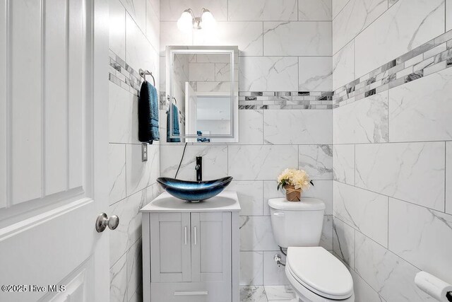 2610 Longleaf Pine Cir, Leland, NC 28451 - half bath featuring toilet, vanity, marble finish floors, and tile walls