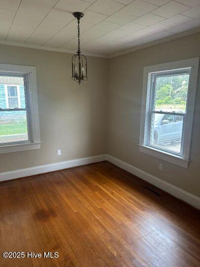 302 N Main St, Robersonville, NC 27871 - empty room featuring crown molding, healthy amount of natural light, wood finished floors, a chandelier, and baseboards