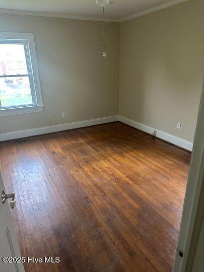302 N Main St, Robersonville, NC 27871 - unfurnished room with crown molding, baseboards, and dark wood-style flooring