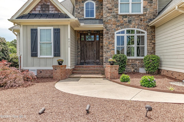 property entrance with stone siding and a standing seam roof