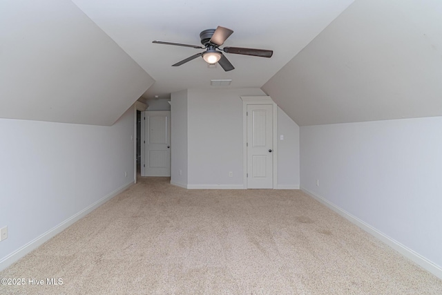 bonus room featuring lofted ceiling, carpet flooring, baseboards, and a ceiling fan