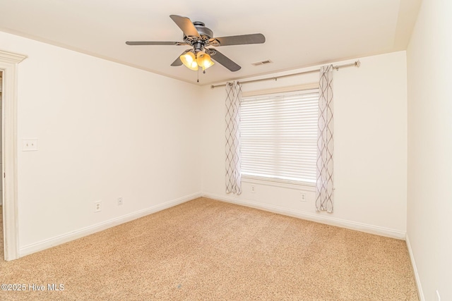 carpeted spare room with a ceiling fan and baseboards
