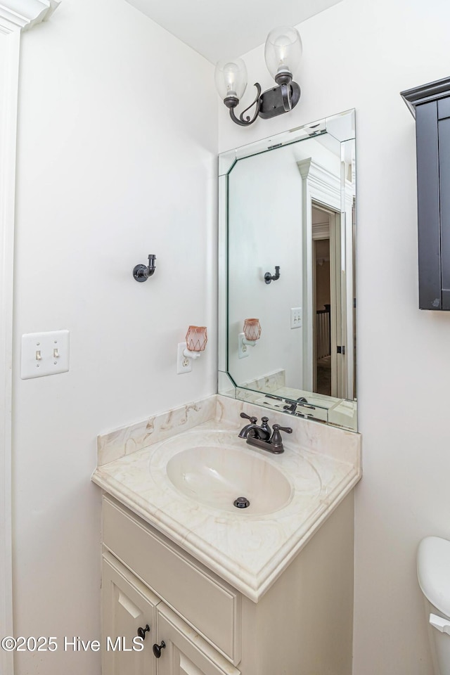 half bath featuring vanity and toilet