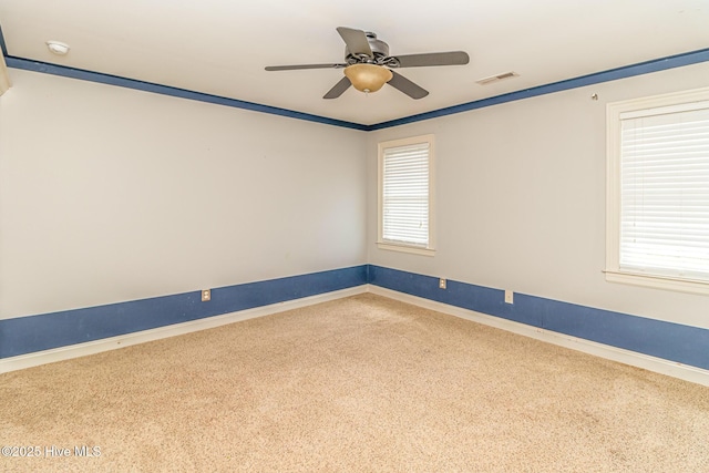 empty room featuring carpet flooring, baseboards, and a ceiling fan