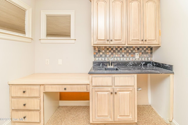 bar area featuring decorative backsplash, a sink, and built in study area