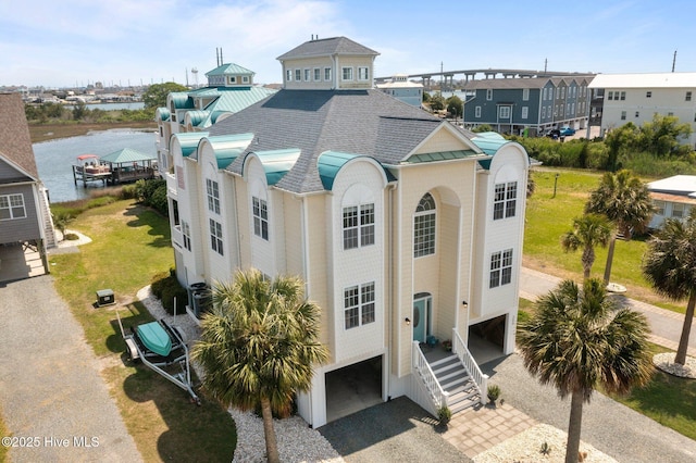 208 Sea Manor Dr, Surf City, NC 28445 - raised beach house with a garage, a shingled roof, gravel driveway, stairs, and a water view