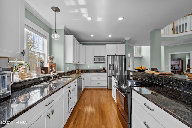 208 Sea Manor Dr, Surf City, NC 28445 - kitchen featuring appliances with stainless steel finishes, a sink, crown molding, white cabinetry, and pendant lighting