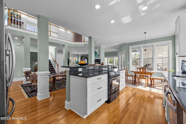 208 Sea Manor Dr, Surf City, NC 28445 - kitchen featuring stainless steel appliances, ornamental molding, light wood-type flooring, white cabinets, and decorative light fixtures