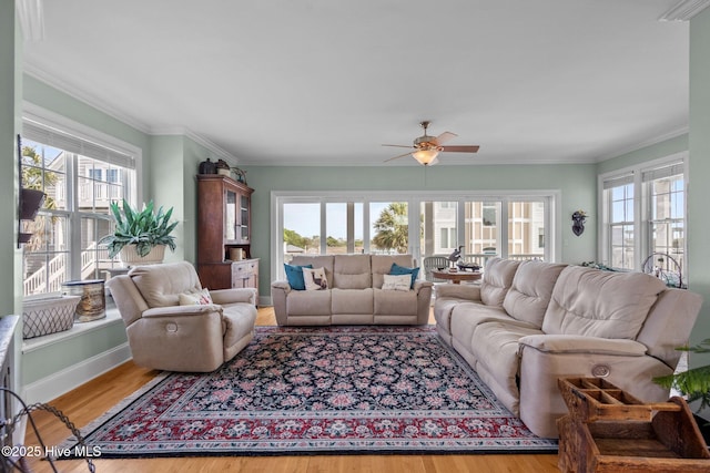 208 Sea Manor Dr, Surf City, NC 28445 - living area featuring healthy amount of natural light, a ceiling fan, wood finished floors, crown molding, and baseboards