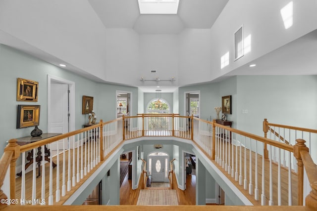 208 Sea Manor Dr, Surf City, NC 28445 - corridor featuring a towering ceiling, an upstairs landing, recessed lighting, wood finished floors, and a skylight