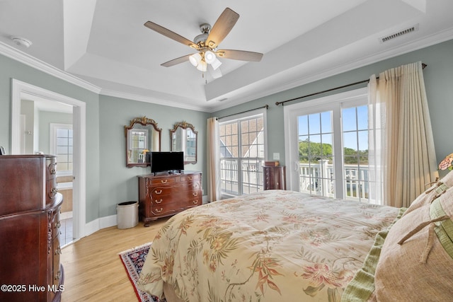 208 Sea Manor Dr, Surf City, NC 28445 - bedroom with access to exterior, a raised ceiling, multiple windows, wood finished floors, and crown molding