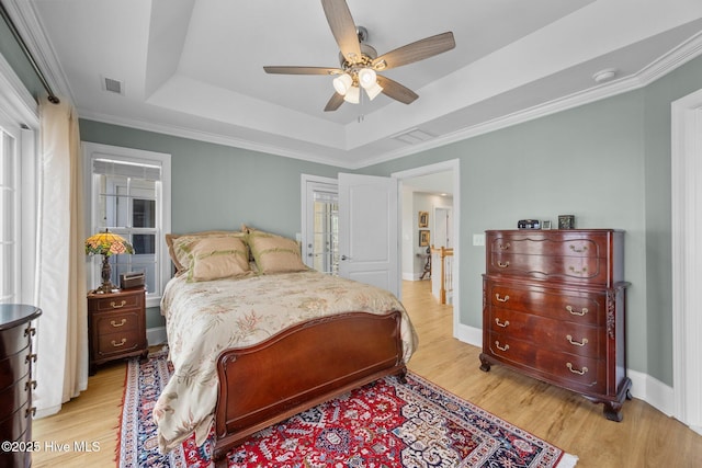 208 Sea Manor Dr, Surf City, NC 28445 - bedroom with a tray ceiling, light wood-style flooring, ceiling fan, and ornamental molding
