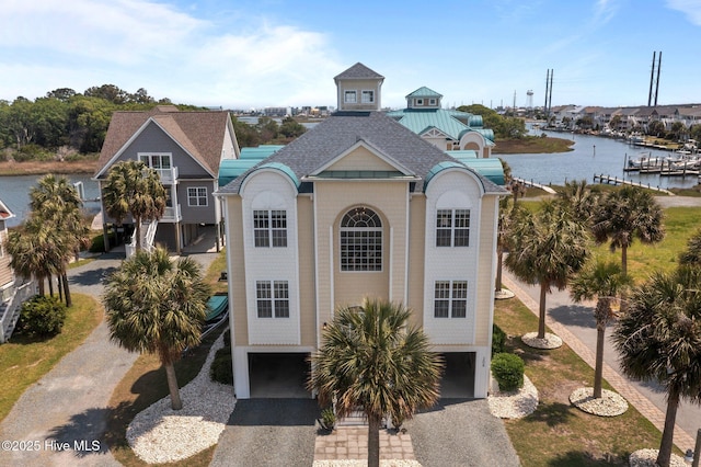 208 Sea Manor Dr, Surf City, NC 28445 - beach home with an attached garage, a water view, a shingled roof, and driveway