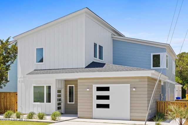 1100 S Sixth St, Carolina Beach, NC 28428 - view of front of house with a shingled roof, board and batten siding, and a garage