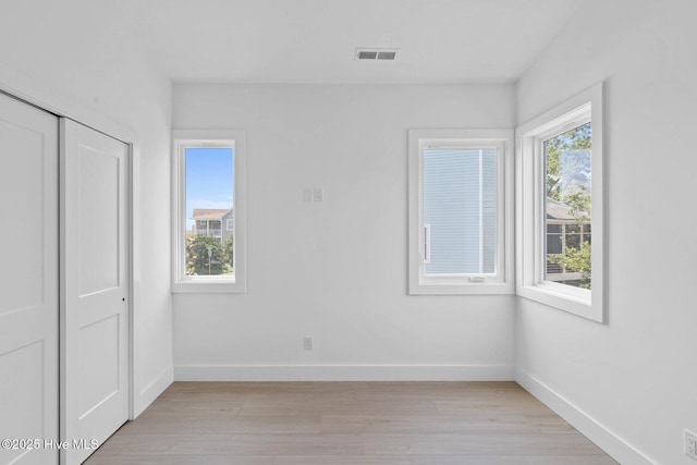 1100 S Sixth St, Carolina Beach, NC 28428 - unfurnished bedroom with light wood-style floors, baseboards, and a closet