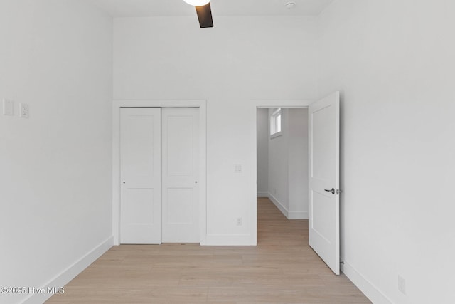 1100 S Sixth St, Carolina Beach, NC 28428 - unfurnished bedroom with light wood-style flooring, baseboards, a closet, and a ceiling fan