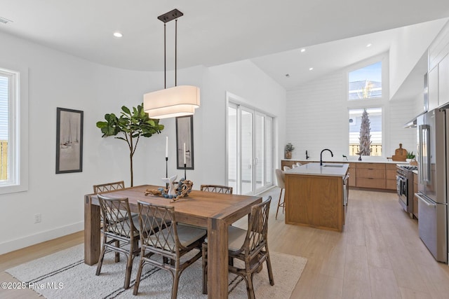 1100 S Sixth St, Carolina Beach, NC 28428 - dining area with light wood-style flooring, recessed lighting, baseboards, and high vaulted ceiling