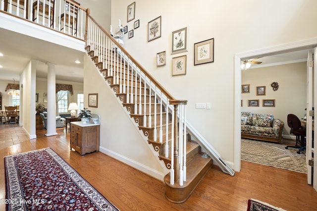 482 Riverwood Dr SE, Bolivia, NC 28422 - stairs featuring ornate columns, ornamental molding, wood finished floors, baseboards, and a ceiling fan