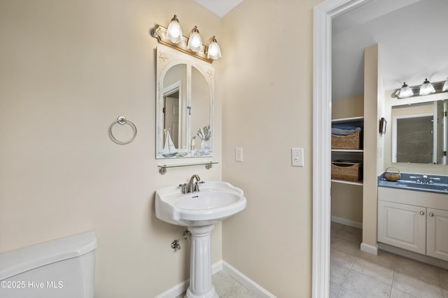 482 Riverwood Dr SE, Bolivia, NC 28422 - bathroom with toilet, tile patterned flooring, a sink, and baseboards