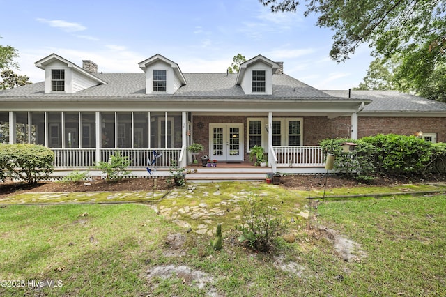 482 Riverwood Dr SE, Bolivia, NC 28422 - view of front of home featuring french doors, a front yard, a chimney, and a sunroom