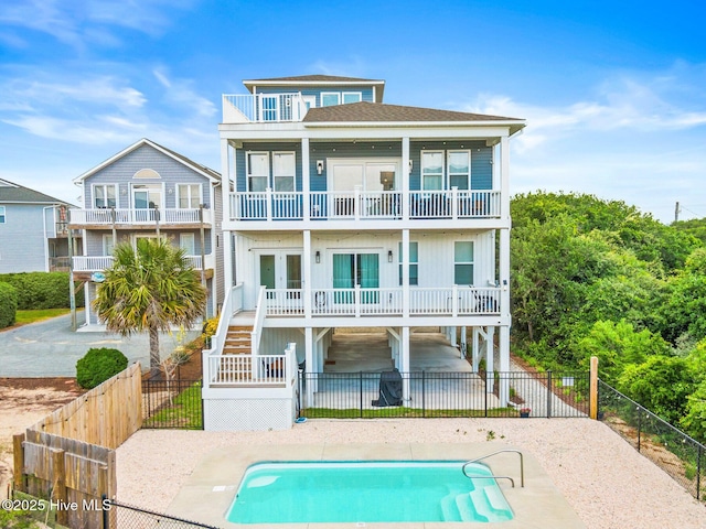 822 S Topsail Dr Unit B, Surf City, NC 28445 - rear view of property with a balcony, stairway, a fenced backyard, a patio area, and roof with shingles