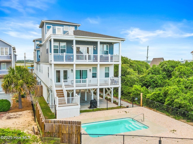 822 S Topsail Dr Unit B, Surf City, NC 28445 - rear view of house featuring a balcony, stairs, a fenced backyard, a shingled roof, and a patio area