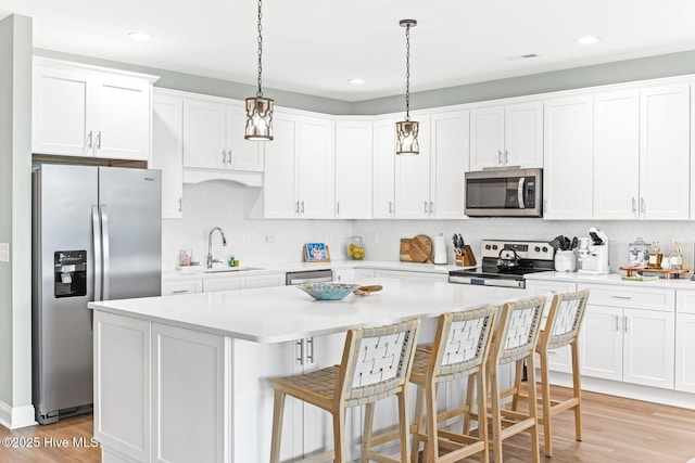 822 S Topsail Dr Unit B, Surf City, NC 28445 - kitchen with stainless steel appliances, a sink, a center island, white cabinets, and recessed lighting