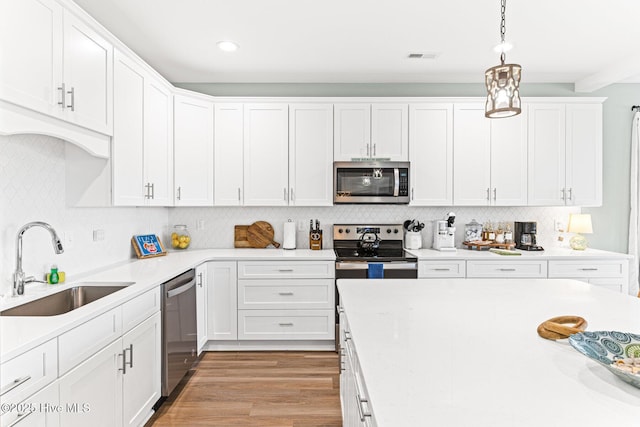 822 S Topsail Dr Unit B, Surf City, NC 28445 - kitchen featuring appliances with stainless steel finishes, a sink, white cabinets, light countertops, and recessed lighting