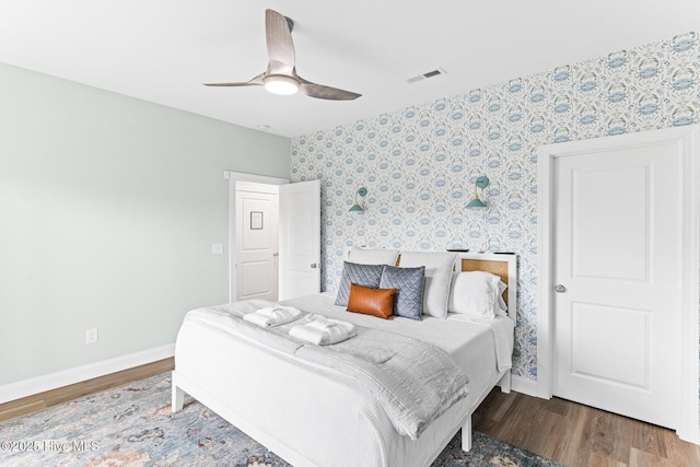 822 S Topsail Dr Unit B, Surf City, NC 28445 - bedroom with wallpapered walls, baseboards, wood finished floors, and a ceiling fan
